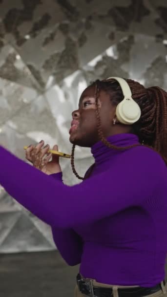 一个非洲酷女人和Vitligo的垂直慢动作视频 她一边唱歌 一边听音乐 一边跳舞 — 图库视频影像