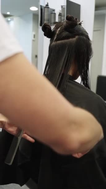 一个无法辨认的女人在理发店理发的后视镜的垂直慢镜头 — 图库视频影像