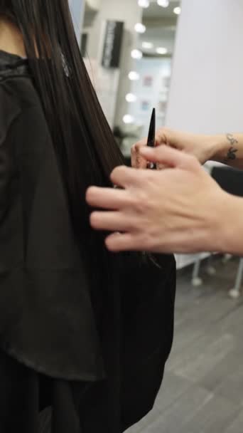 发型师用剪子在发廊中精确剪发的侧向后看的垂直慢动作特写视频 — 图库视频影像