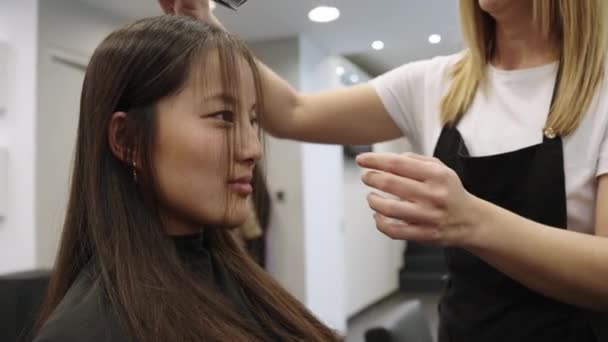 Spowolniony Film Kaukaskim Fryzjerem Czesającym Włosy Pięknej Chinki Wyciąć Salonie — Wideo stockowe