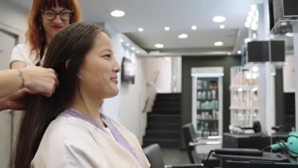 一名中国妇女在美发店梳头时与理发师交谈的慢镜头 — 图库视频影像