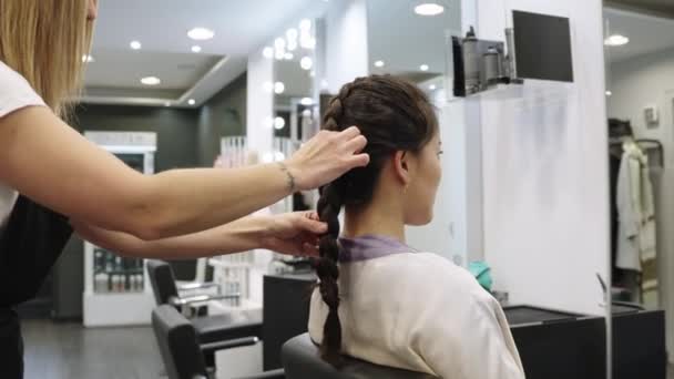 慢镜头 一个精心理发的中国女人在美发厅的镜子前整理辫子 — 图库视频影像