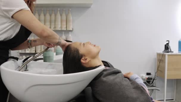 中国女人在美发店享受洗头时把头靠在洗头槽上的慢镜头 — 图库视频影像