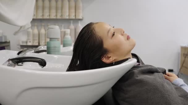 慢镜头 一个无法辨认的中国女性客人在美容院洗完头发后用毛巾擦干头发的镜头 — 图库视频影像