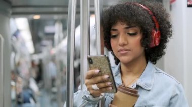 Şehvetli bir trans kadının metroda kahve içerken cep telefonunu kullanmasının yavaş çekim videosu.
