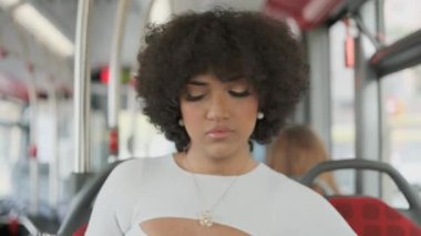 Ciddi bir İspanyol transseksüel kadının otobüsle seyahat ederken cep telefonu kullanmasının yavaş çekim videosu.