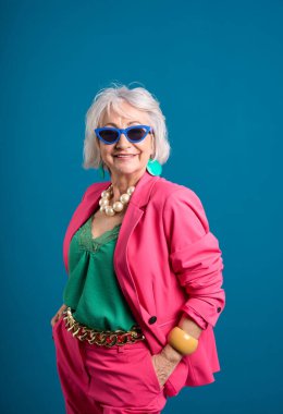 Pembe Takım Elbiseli ve Mavi Gözlüklü Şık Kıdemli Kadın