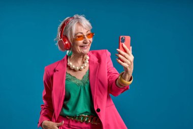 Son sınıf öğrencisi bayan kulaklıkla selfie çekiyor.