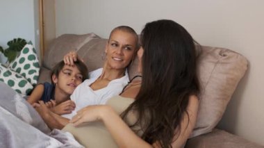 Çok ırklı lezbiyen bir ailenin ve çift ırklı olmayan bir çocuğun koltukta gevşeyip konuştuğu yavaş çekim videoları.