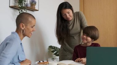 Lezbiyen annelerin evde ödevlerini iyi yaptığı için ikili olmayan çocuklarını alkışladıkları yavaş çekim videoları.