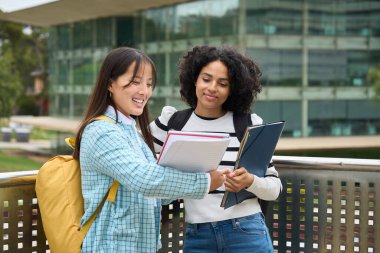 Students sharing notes outside the University