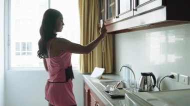 Bangkok 'taki transseksüel kadın mutfağında akıllı telefonuyla fotoğraf çekerken farklı pozlar veriyor.