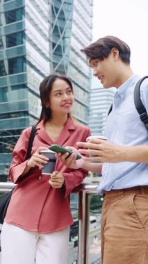 Genç çift, ağır çekimde akıllı telefona bakarken kahkahalarla gülüyor.