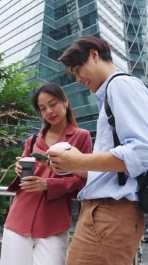 Akıllı telefon kullanıp kahve içen Asyalı genç bir çiftin yavaş çekim montajı.