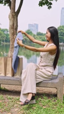 Bangkok Parkı 'nda giysileri ağır çekimde açan genç bir kadın.