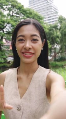 Bangkok parkında ağır çekimde vlog yapan genç bir kadın.