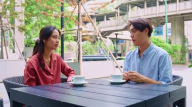 Genç profesyoneller Bangkok 'ta açık bir kafede ciddi bir sohbete giriştiler. Önemli konuları kahve içerken tartıştılar.