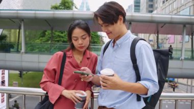 Ağır çekim, Bangkok, Tayland 'da bir yaya köprüsünde akıllı telefon kullanan iki Asyalı profesyoneli yakalıyor.