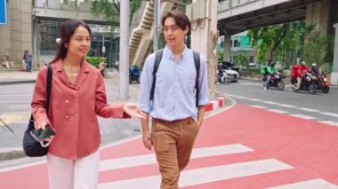 Genç profesyoneller, hareketli bir şehirde yürürken iş konuşuyorlar, rahat ve kendinden emin bir anın tadını çıkarıyorlar.