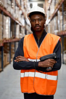 Bir dağıtım merkezinde barkod tarayıcısı tutan, envanter ve lojistik işlemlerini yöneten kendinden emin bir depo çalışanı.