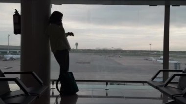 Turist, Bangkok, Tayland 'daki Suvarnabhumi havaalanında uçak beklerken bir telefon görüşmesi yapıyor.