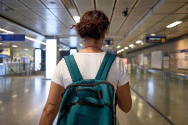 Bangkok 'u keşfeden kadın turist, modern ve verimli metro sistemini kullanarak, bir sırt çantası taşıyor.