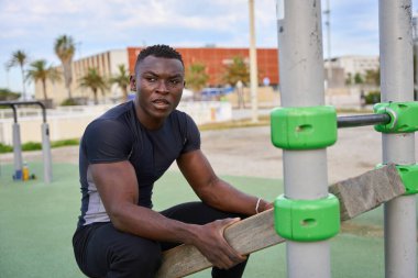 Jimnastik parkında ahşap paralellerle yapılan odaklanılmış atlet eğitimi, dayanıklılık ve forma olan bağlılığını gösteriyor.