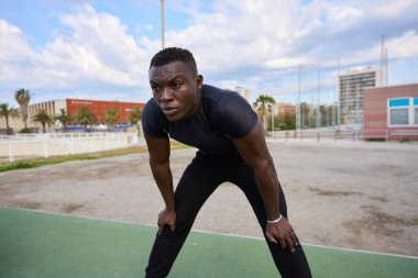 Açık hava spor sahasında yapılan yoğun jimnastik eğitiminden sonra dinlenen yorgun sporcu