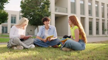 Canlı bir tartışmayla meşgul olan üç üniversite öğrencisi canlı bir kampüs bahçesinde birlikte okuyorlar.