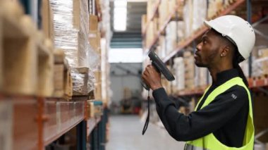 Depo çalışanı, yavaş çekimde raflardaki paketleri tarıyor ve lojistik ve envanter işlemlerini gösteriyor.