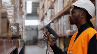 Depo çalışanı ağır çekimde barkod tarayıcısı kullanarak bir depodaki eşyaları tarıyor.