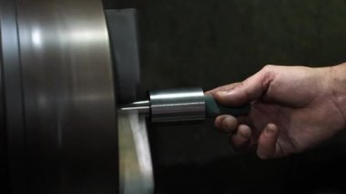 Torna tezgahında ustalıkla metal parçaları makinelemek, üretim için özel endüstriyel bileşenler yaratmada hassasiyet göstermektedir.