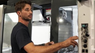 Yetenekli teknisyen, endüstriyel parçaların hassas üretimi ve üretim ortamında özel prototipler için kontrolleri ayarlayan bir cnc makinesi kullanıyor.