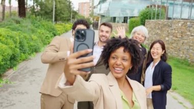 İş adamları açık hava ortamında grup selfie 'si çekiyor.