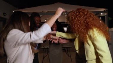 Çok ırklı genç yetişkinler dans ediyor ve neşe ve neşe dolu, gece gökyüzünün altında canlı bir çatı partisinin tadını çıkarıyorlar.