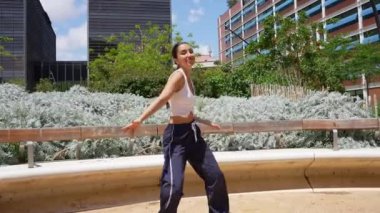 Şehir parkında akışkan hareketler yapan profesyonel dansçı dinamik koreografi ve tutkulu hareketlerle yaratıcılığını ifade ediyor.