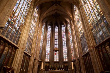 Güneş ışığı, Belçika kilisesindeki renkli vitray pencereleri aydınlatarak ruhani bir atmosfer yaratıyor.