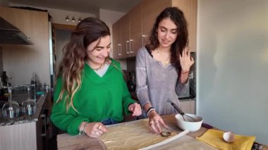 İki kadın evcil bir mutfakta yemek hazırlıyor, eğleniyor ve sevgililer gününü kutluyorlar.