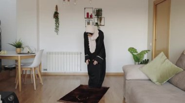 Müslüman kadın salah 'ı yavaş çekimde bir oturma odası ortamında yapıyor, bir ibadet ayini sırasında kendini adamış ve ruhaniliğini gösteriyor.