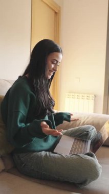 Konforlu bir ev ortamından çevrimiçi öğrenme oturumuna katılan bir kadının laptopuyla yavaş çekim videosu