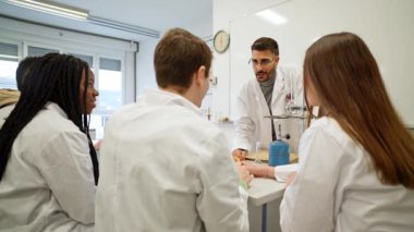Öğrenciler etkin bir kimya laboratuarı oturumuna katılırlar, deneylerle ilgilenirler ve bir sınıf ortamında bilimsel kavramları tartışırlar.