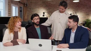 Bir proje üzerinde işbirliği yapan, fikirleri paylaşan ve modern bir çalışma alanında birlikte çalışan iş adamları.