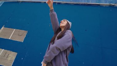 Canlı mavi arka plan, dinamik bayan dansçı tutkulu hip hop hareketleri yapıyor enerjik ritim ve şehir tarzı sokak tarzıyla