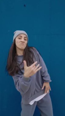 Enerjik hip hop dansçıları canlı mavi bir zemin üzerinde çeşitli hareketler ve ifadeler sergiliyor.