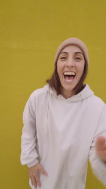 Enerjik hip hop dansçısı çeşitli hareketler sergiliyor ve canlı sarı bir arka plana gülümsüyor.