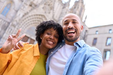 Mutlu turistler Barselona, İspanya 'da selfie çekiyorlar. Kadın barış işareti yapıyor, tatillerinin tadını çıkarıyorlar.
