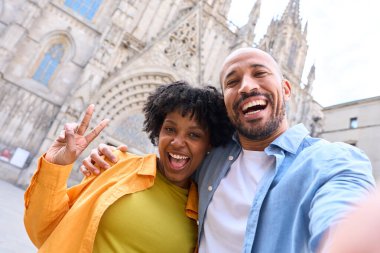 Barselona katedralinin önünde zafer tabelasıyla selfie çeken mutlu turistler.