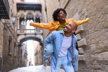 Barselona 'da, Gotik Mahallede, ünlü Carrer del Bisbe Köprüsü' nün altında, dar bir sokakta, mutlu turist çiftler eğleniyor.