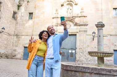 Barcelonas Gotik Mahallesi 'nde Santa Félip Neri yakınlarında selfie çeken mutlu turistler İspanya' da tatillerinin tadını çıkarıyorlar.
