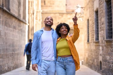 Barselona 'da yürüyen ve gezen mutlu turistler, Gotik mahallede ilginç bir şeye işaret eden kadınlar.